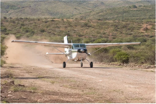 Light aircraft flying above East African savannah