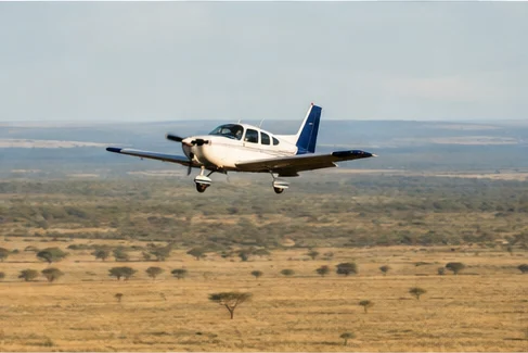 Light aircraft flying above East African savannah