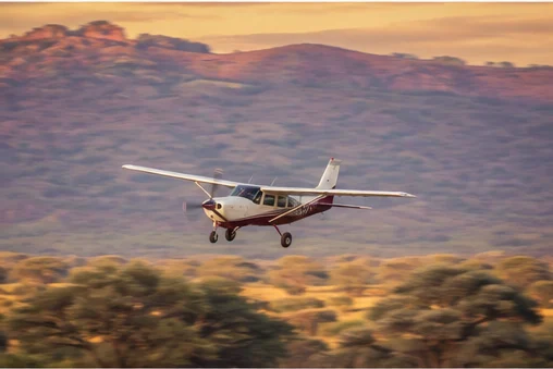 Light aircraft flying above East African savannah